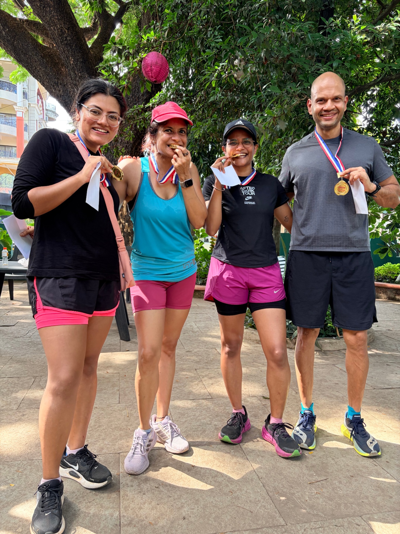 The winning team of Mini Trippin' holding up and biting their medals together after the race